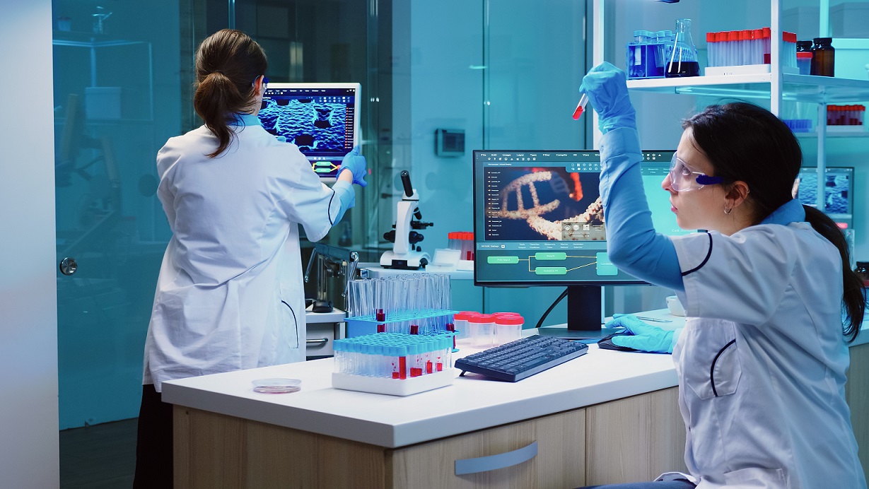 Group of scientists wearing lab coat working in laboratory while examining biochemistry sample in test tube and scientific instruments. Science technology research and development study concept.